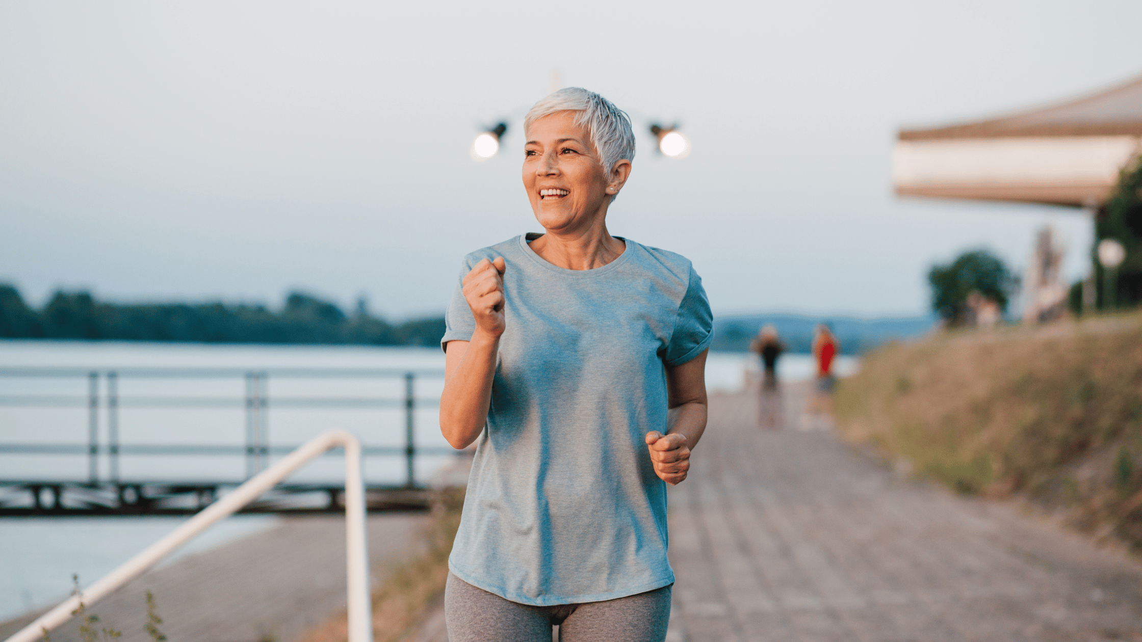 Older woman running outdoors while smiling—representing the strength and energy possible with chair yoga for seniors.